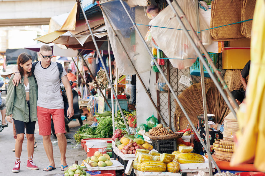 Un hombre y una mujer observan la comida de un mercado tradicional chino